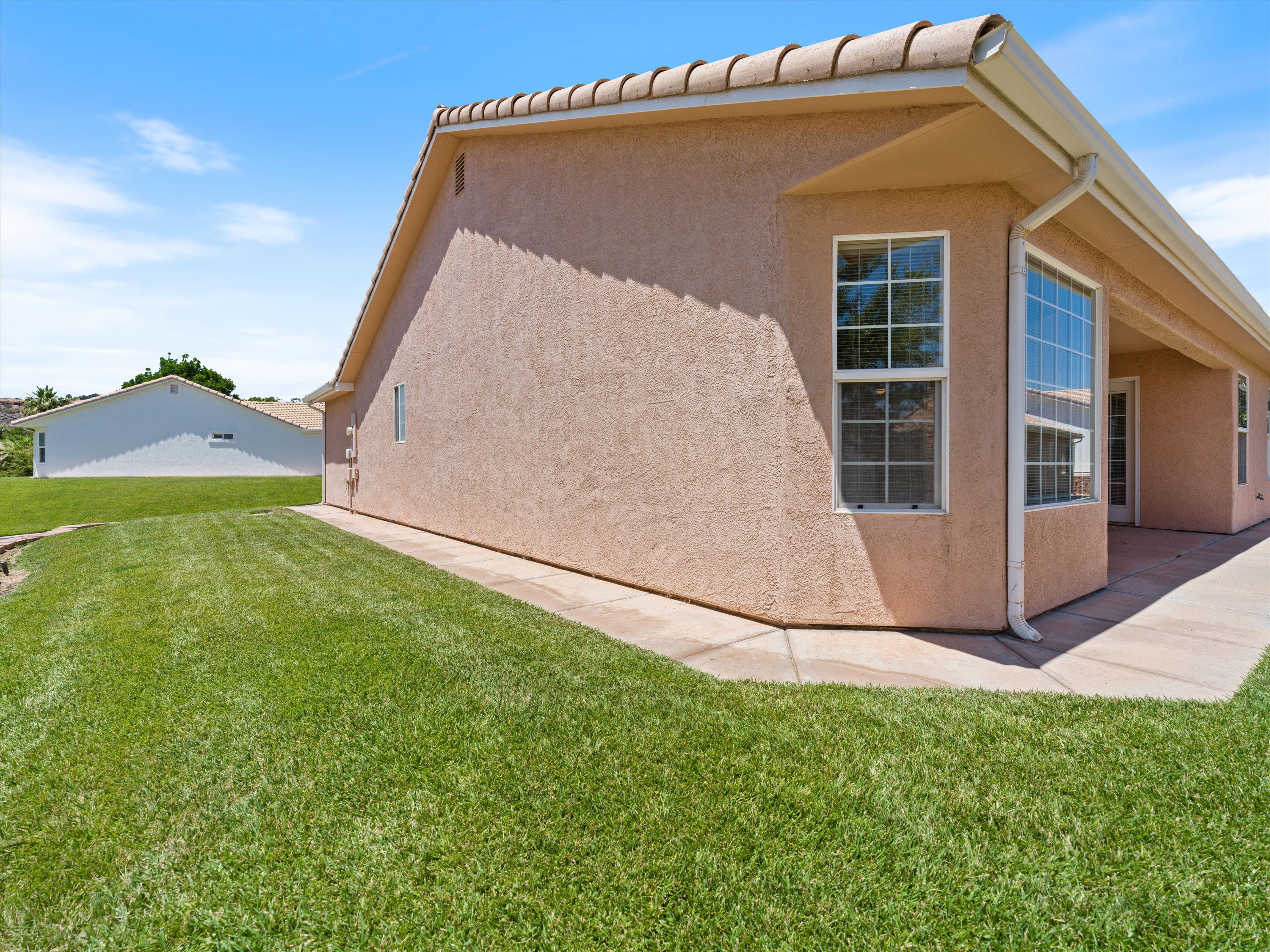 Stucco exterior with a tiled roof and rain gutters