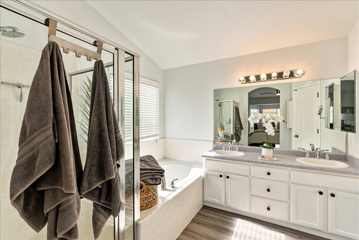 Bathroom featuring a double vanity with ample storage, a large mirror, and a five-light fixture