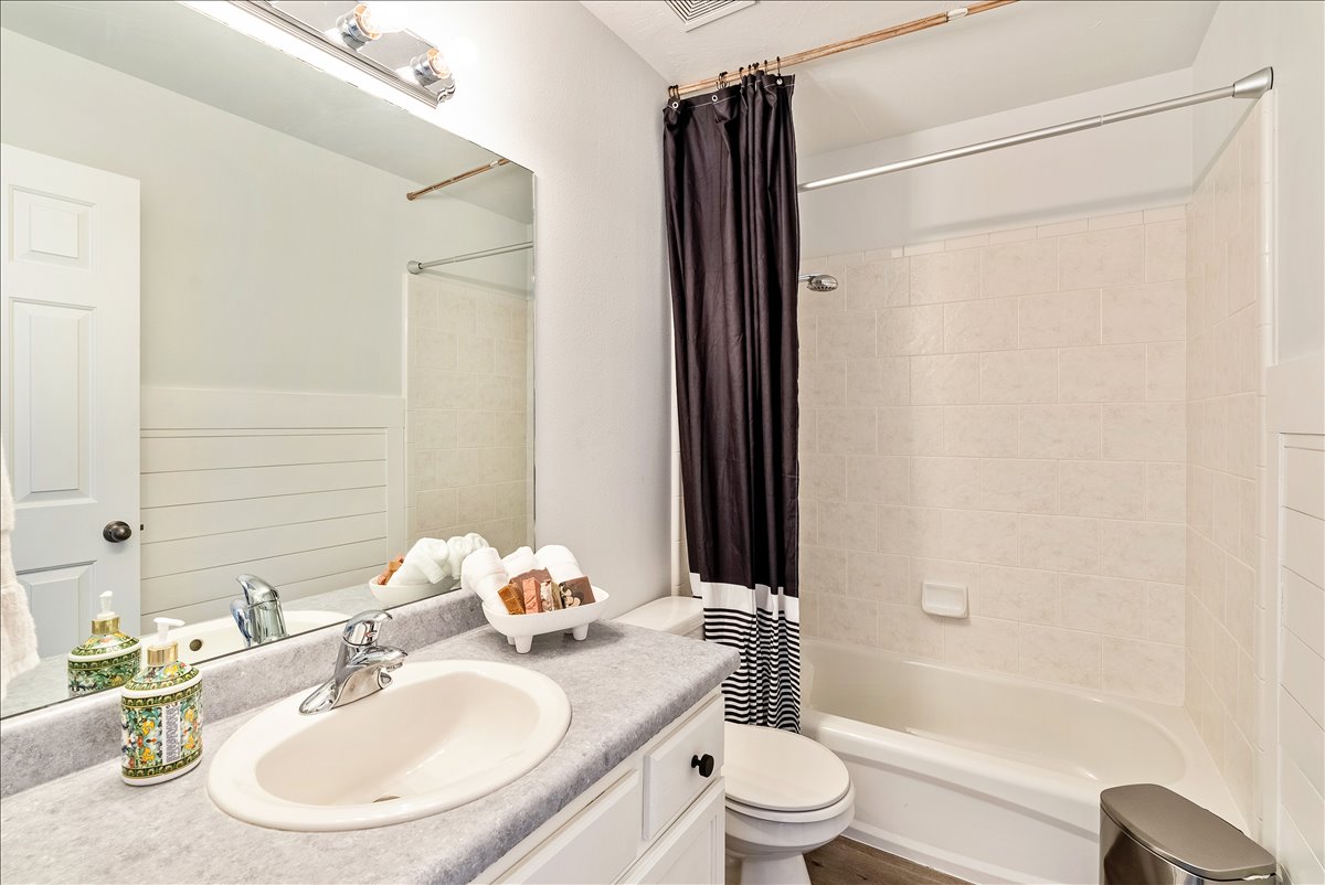 Bathroom featuring a single vanity with an oval sink, chrome faucet, and gray countertop