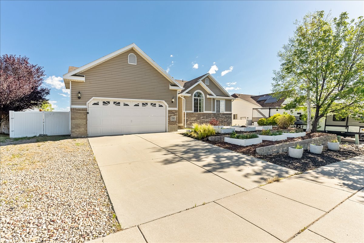 Property exterior featuring a two-car garage, concrete driveway, and stone veneer accents