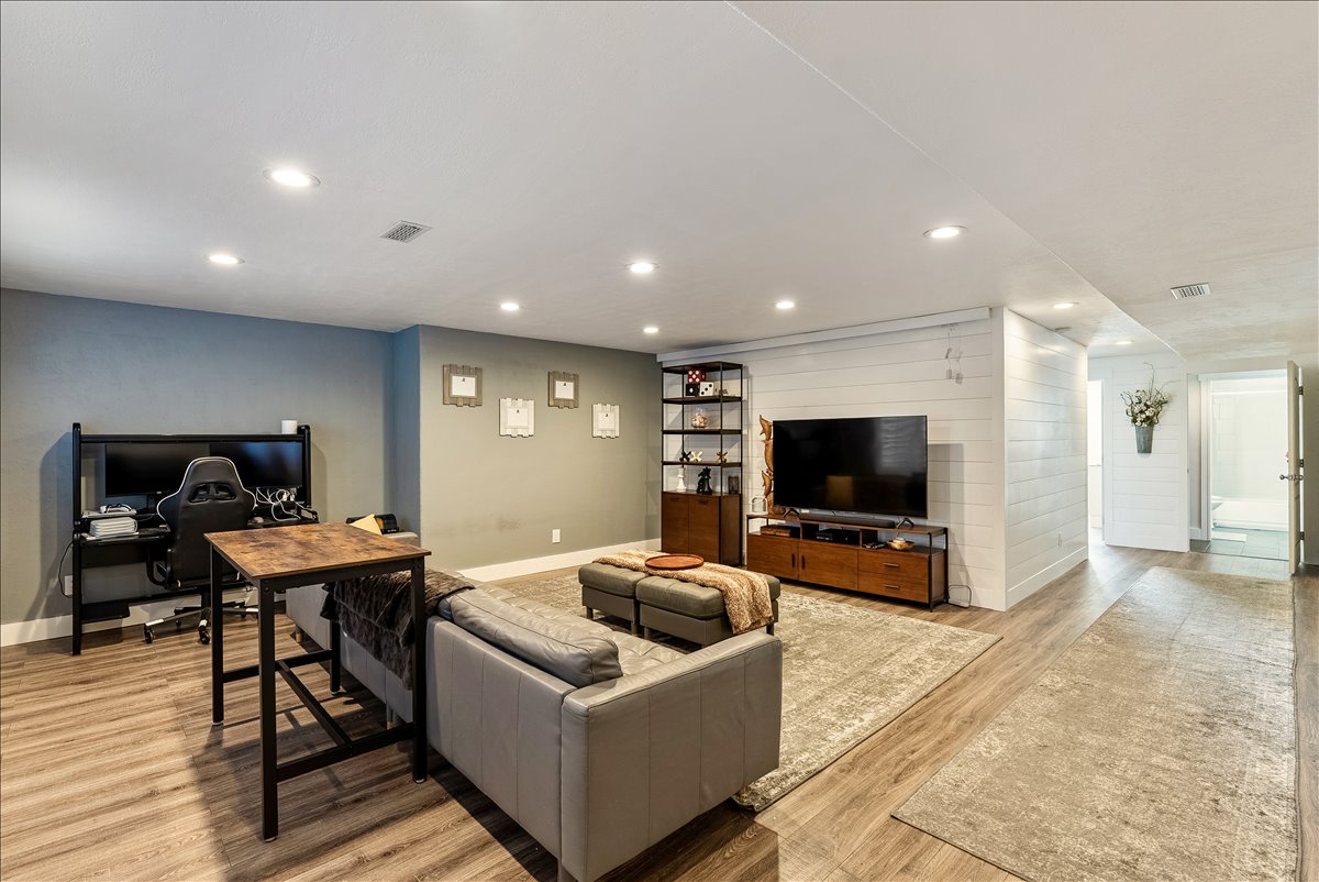 Spacious room featuring wood-finish flooring, recessed lighting, and a neutral color palette