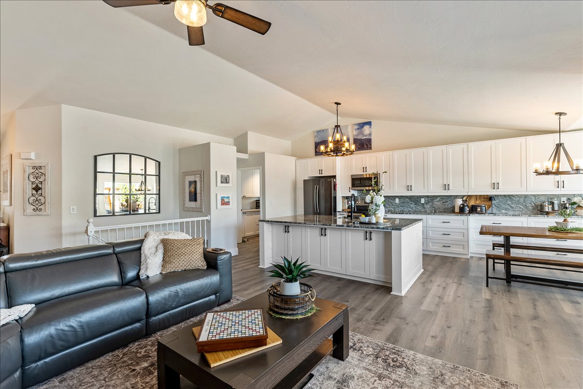 Open-concept living space featuring wood-finish flooring and vaulted ceilings