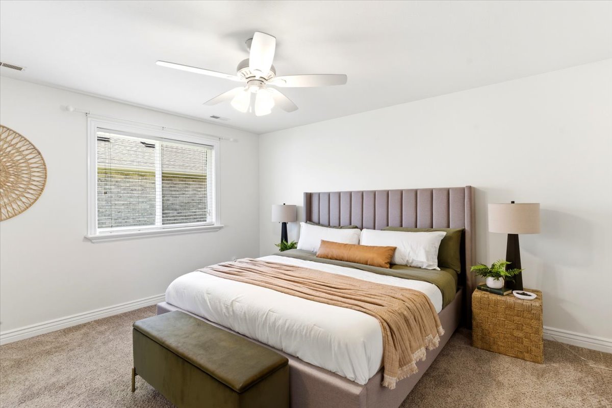 Bedroom featuring light-colored carpeting, a window with blinds, and white walls