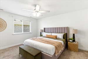 Bedroom featuring light-colored carpeting, a window with blinds, and white walls