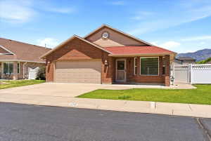 Brick exterior with a prominent two-car garage, red shingle roofing, and a front porch entry