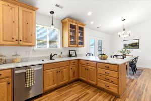 Kitchen with light wood cabinetry, light-toned countertops, and wood-finish flooring