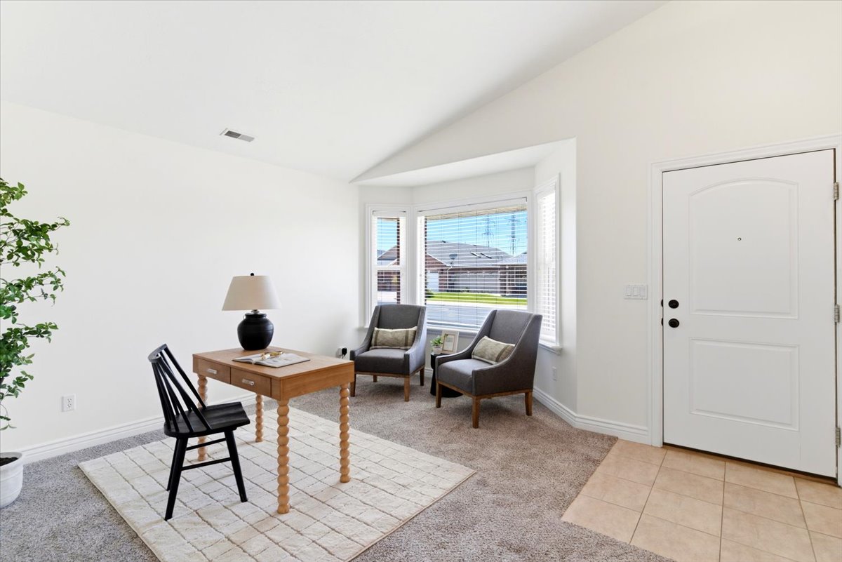 Entryway featuring a paneled door, tiled flooring, vaulted ceilings, and a bay window