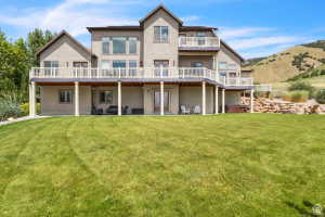 Expansive rear exterior featuring a two-story design with multiple balconies and a covered patio area