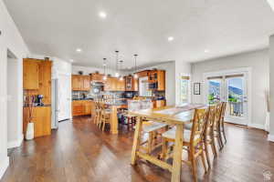 Open-concept kitchen and dining area featuring wood-finish flooring, recessed lighting, and a kitchen island with pendant lighting
