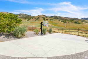 Expansive concrete pad bordered by gravel landscaping, featuring a basketball hoop
