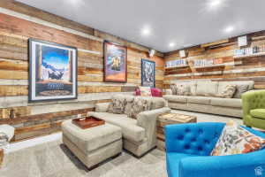 Reclaimed wood paneling accents a spacious room featuring recessed ceiling lighting, a light-toned carpeted floor, and white floating shelves