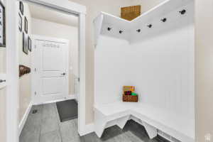 Built-in white storage bench with upper hooks and beadboard detailing