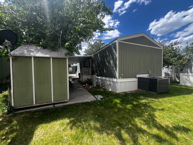 Green siding exterior featuring white trim and a gabled roofline