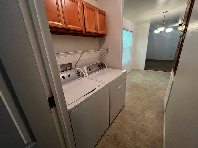 Laundry area with overhead wood cabinetry and tile flooring