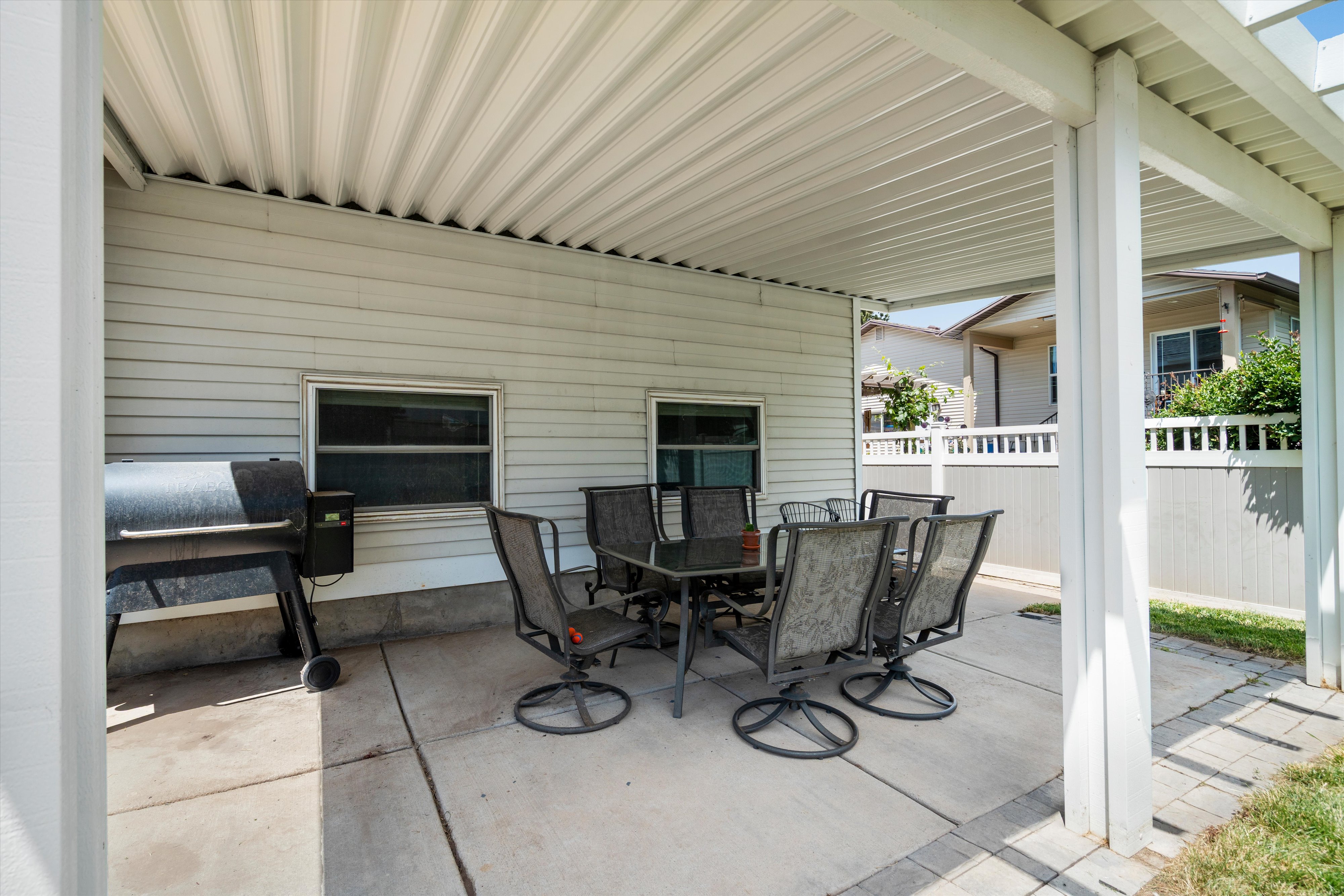 Covered patio featuring concrete flooring, a white slatted ceiling, and white siding
