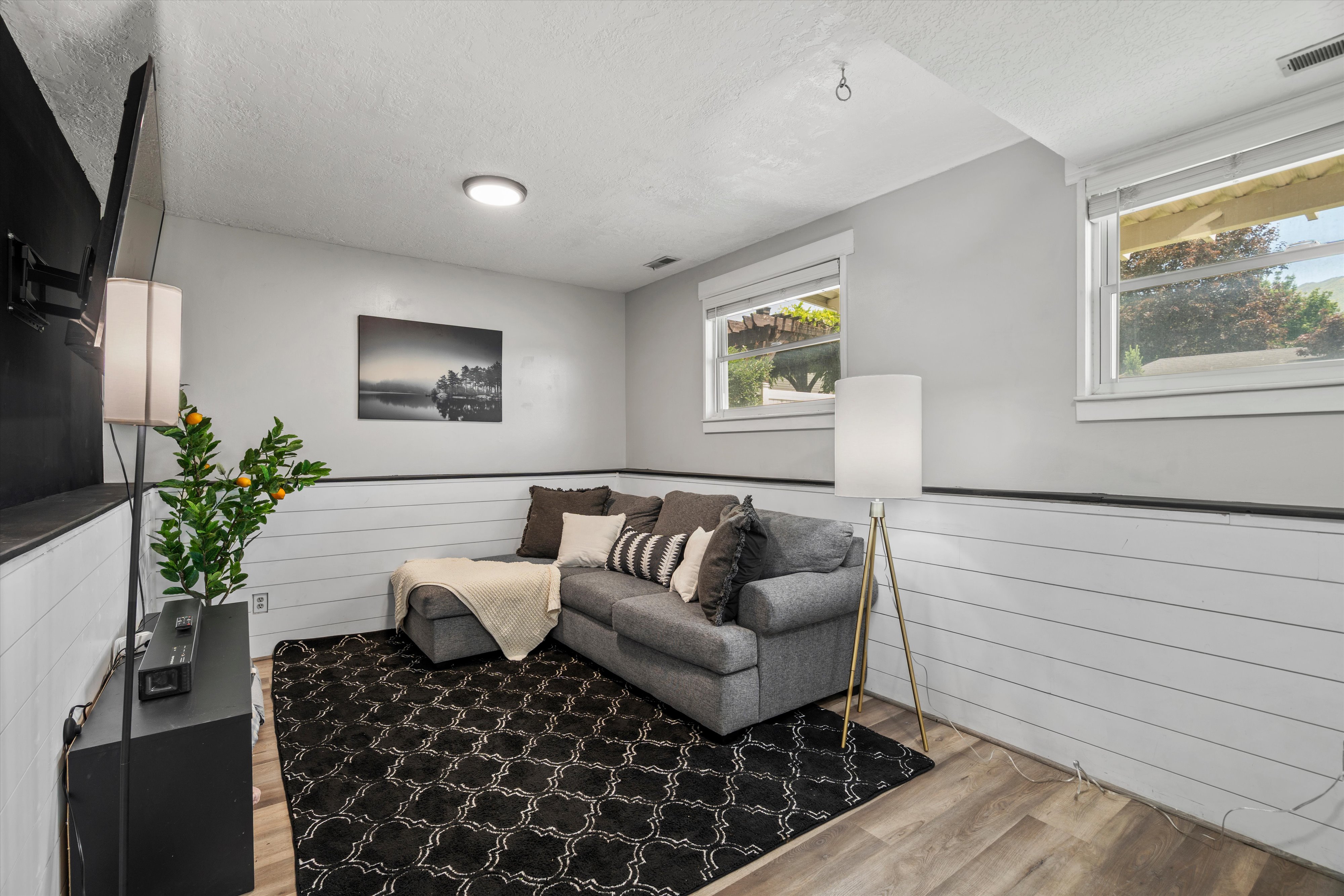 Living area featuring wood-finish flooring, white shiplap wainscoting, and recessed lighting
