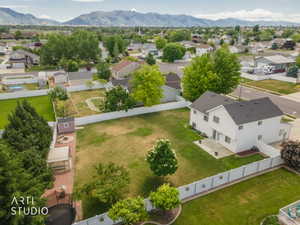 Expansive backyard featuring a large green space, white privacy fencing, and a dedicated patio area