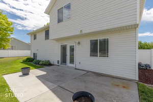 Rear exterior with white horizontal siding and a concrete patio