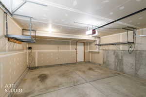 Spacious garage featuring concrete flooring and exposed concrete foundation wall