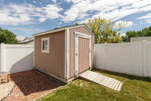 Freestanding shed with a window, single door, and a wooden ramp