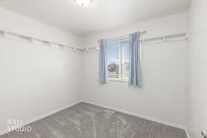 Bedroom featuring light gray carpeting, neutral wall paint, and a window with blinds