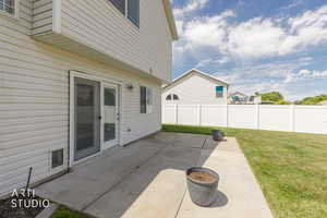Spacious concrete patio with sliding screen door access to the interior