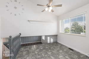 Upper-level landing featuring textured tile flooring, a large window with horizontal blinds, a ceiling fan with integrated lighting, and a painted wood railing
