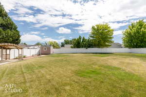 Expansive green lawn with a white privacy fence