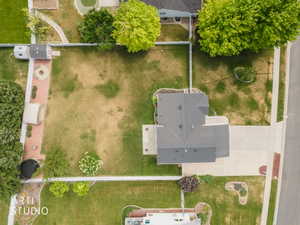 Spacious backyard featuring a substantial lawn, mature trees, a dedicated fire pit area, and a storage shed