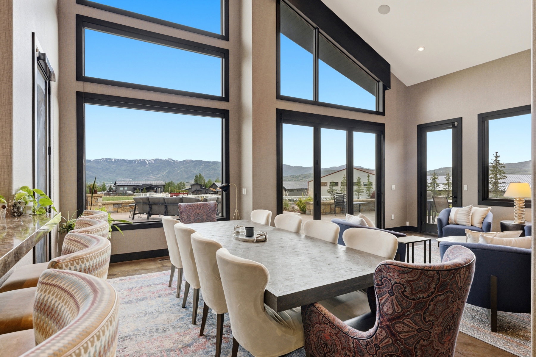 Dining area featuring vaulted ceilings, floor-to-ceiling windows, and a large dining table