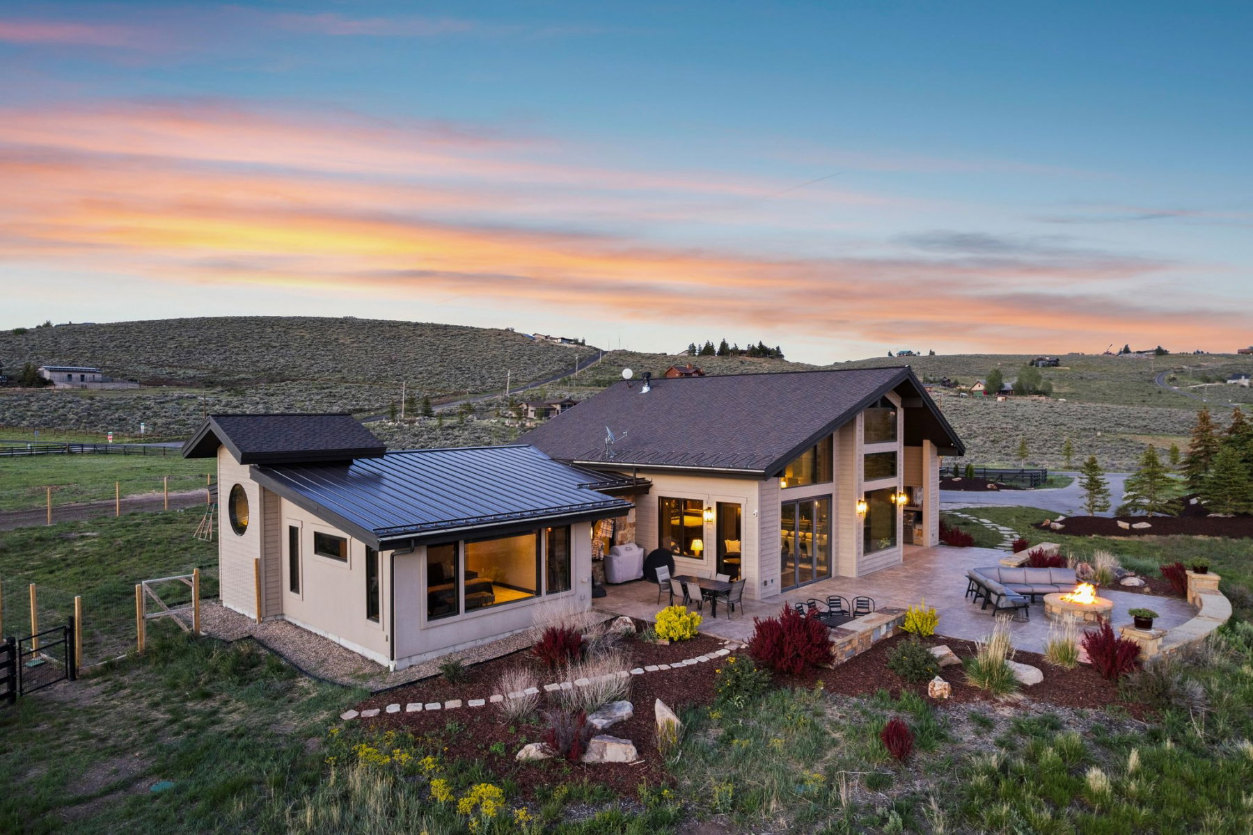 Contemporary residence featuring a spacious patio with a built-in fire pit, multiple seating areas, and architectural landscaping