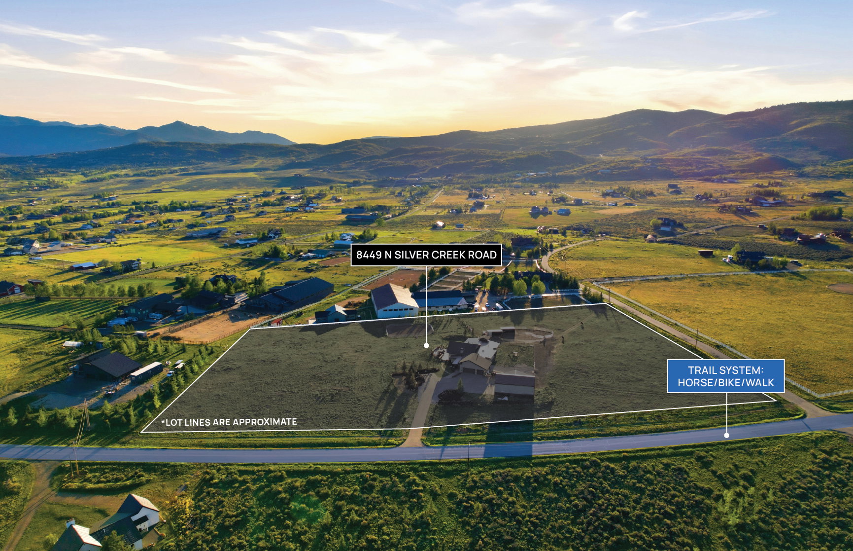Expansive lot featuring a single-story residence and a surrounding landscape of green fields and distant mountains