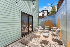 Patio area featuring a mountain mural accent wall, string lighting, and a sliding glass door entry to the building