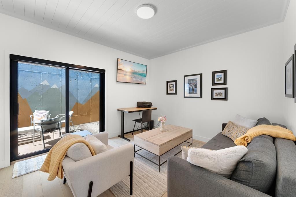 Living area featuring light wood-finish flooring, white walls, and a white plank ceiling