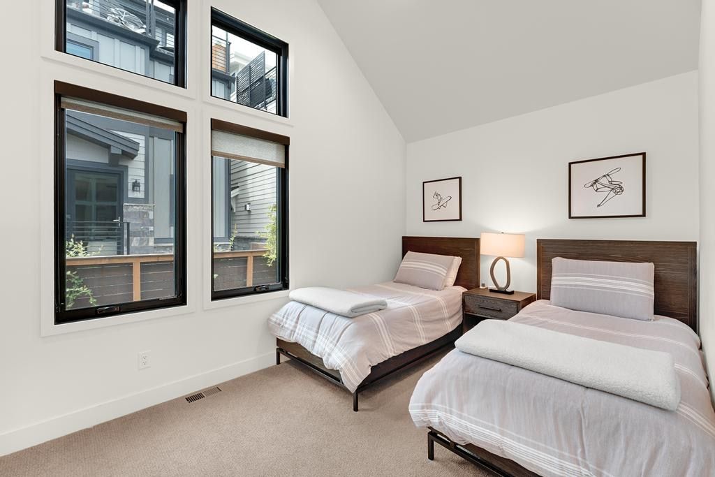 Accentuated by an angled ceiling, this room features a large window array with black frames, offering multiple panes