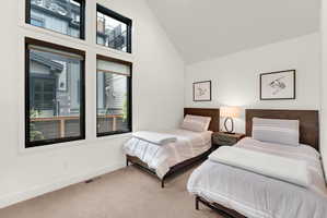 Accentuated by an angled ceiling, this room features a large window array with black frames, offering multiple panes