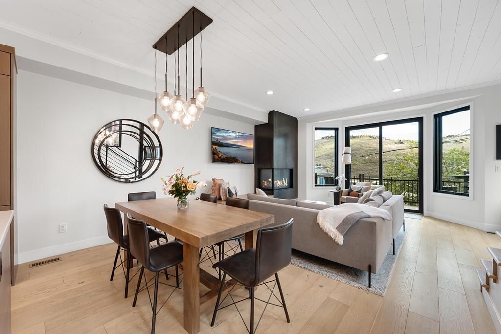 Open-concept living space featuring wood-finish flooring, a modern fireplace, and a shiplap ceiling