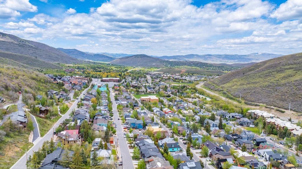 Expansive mountain valley community featuring residential properties, commercial establishments, and verdant hillsides