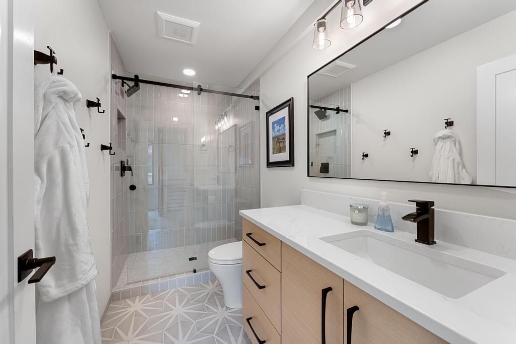 Full bathroom featuring a single vanity with wood-finish cabinetry, a white countertop, and an integrated rectangular sink