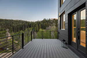 Expansive outdoor deck featuring composite decking, black metal railings, and a contemporary dark-paneled exterior