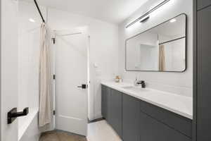 Modern bathroom featuring a single vanity with a white countertop, undermount sink, and matte black faucet