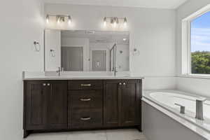 Spacious bathroom featuring a double vanity with dark wood cabinetry and a white countertop