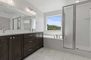Bathroom featuring a double vanity with dark wood cabinetry, white countertops, and brushed nickel fixtures