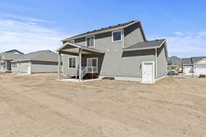 Contemporary stucco exterior with a covered patio featuring a concrete slab and white railing
