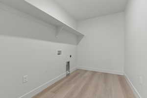 Laundry area with wood-finish flooring, white walls, and a built-in shelf