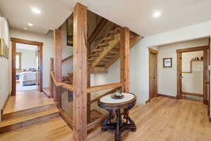 Wood-finish flooring throughout, featuring a natural wood staircase with metal mesh railing