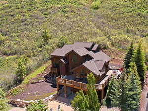 Multi-level residence featuring a brown shingle roof, extensive wood siding, and multiple balconies