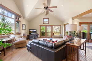 Living area featuring vaulted ceilings with exposed beams, wood-finish flooring, and recessed lighting
