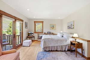 Spacious room featuring wood-finish flooring, recessed lighting, and a private balcony with double glass doors