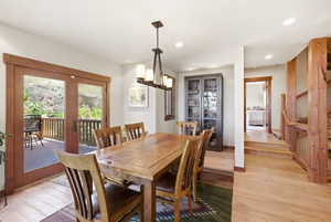 Dining area featuring wood-finish flooring, recessed lighting, and a linear chandelier